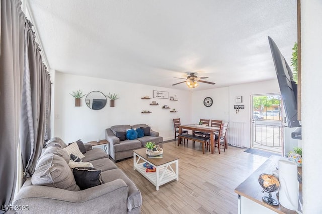 living area with ceiling fan and light wood-style flooring
