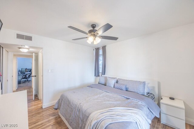 bedroom featuring baseboards, light wood-type flooring, and ceiling fan