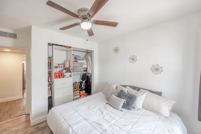 bedroom with wood finished floors, a closet, baseboards, and ceiling fan