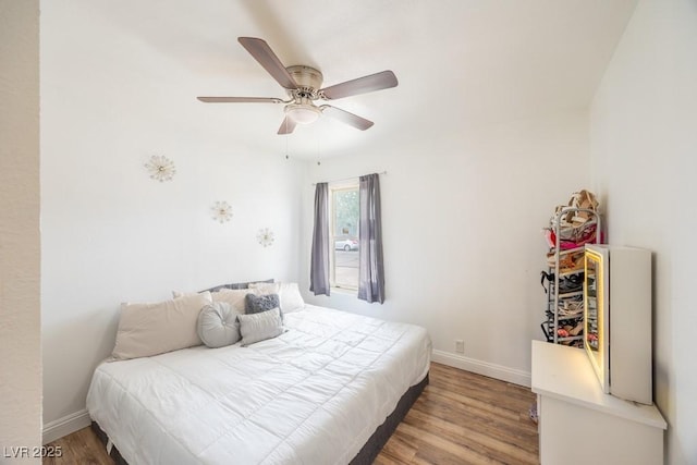 bedroom featuring light wood-style floors, baseboards, and ceiling fan