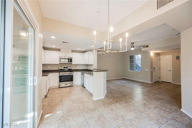 6868 Sky Pointe Dr Unit 1112, Las Vegas, NV 89131 - kitchen featuring appliances with stainless steel finishes, dark countertops, a chandelier, open floor plan, and white cabinetry