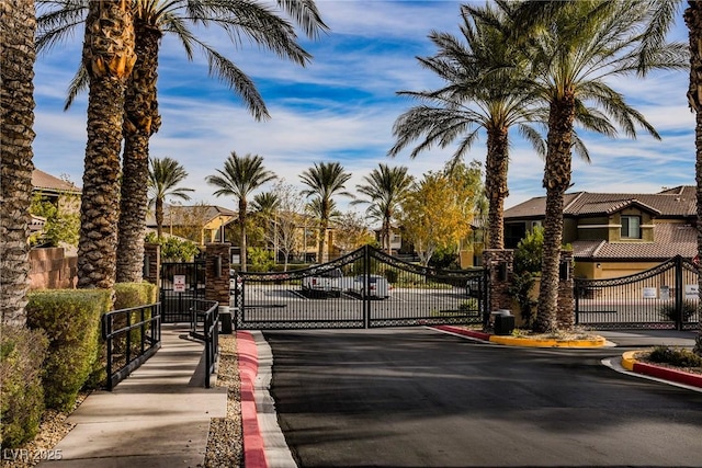6868 Sky Pointe Dr Unit 1112, Las Vegas, NV 89131 - view of asphalt street with a gate, curbs, a gated entry, and a residential view