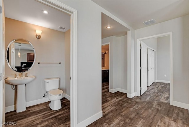 bathroom with wood finished floors, toilet, baseboards, and recessed lighting
