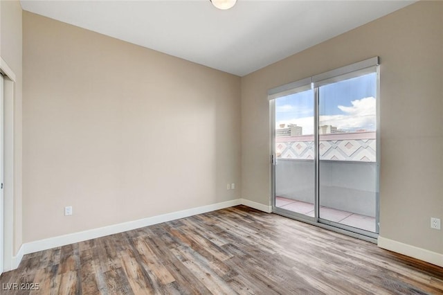 unfurnished room with wood finished floors and baseboards