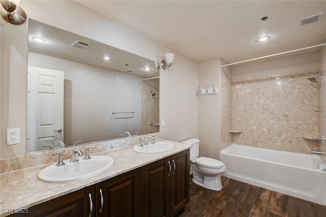 full bath featuring toilet, shower / bathtub combination, wood finished floors, and double vanity