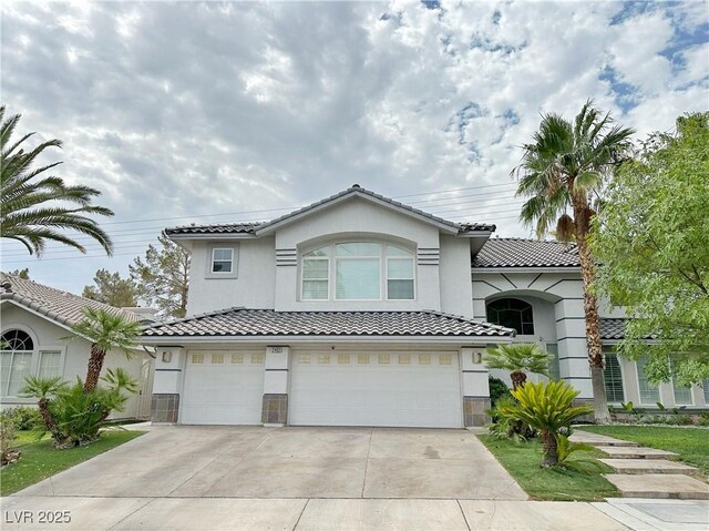 2451 Tour Edition Dr, Henderson, NV 89074 - view of front of property featuring a garage, concrete driveway, stucco siding, and a tile roof