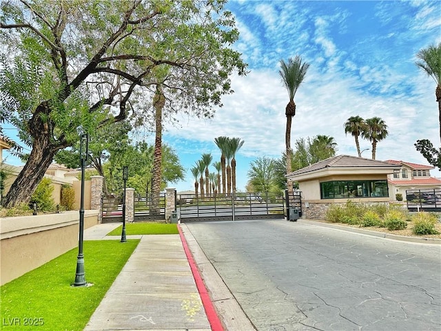 2451 Tour Edition Dr, Henderson, NV 89074 - view of asphalt road with a gate, curbs, sidewalks, and a gated entry