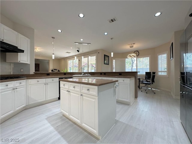 2451 Tour Edition Dr, Henderson, NV 89074 - kitchen with a peninsula, recessed lighting, light wood-style flooring, dishwasher, and under cabinet range hood