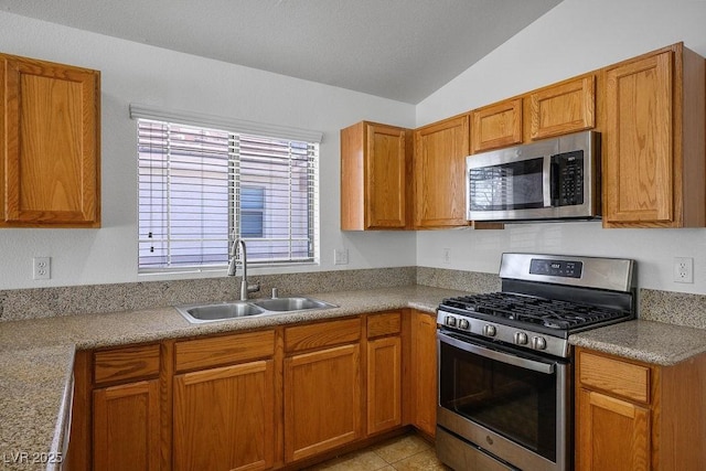 7755 Pacific Rim Ct, Las Vegas, NV 89139 - kitchen with appliances with stainless steel finishes, a sink, vaulted ceiling, brown cabinets, and light countertops