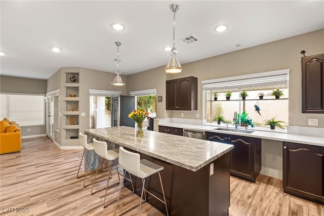 8100 Lake Hills Dr, Las Vegas, NV 89128 - kitchen with a sink, a center island, stainless steel dishwasher, a kitchen breakfast bar, and dark brown cabinetry