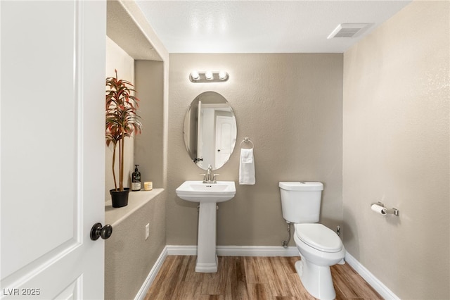 8100 Lake Hills Dr, Las Vegas, NV 89128 - half bathroom with wood finished floors, toilet, and baseboards