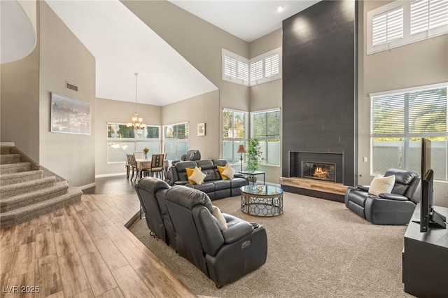 8100 Lake Hills Dr, Las Vegas, NV 89128 - living room with a towering ceiling, a chandelier, wood finished floors, baseboards, and a fireplace