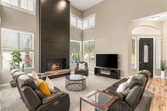 8100 Lake Hills Dr, Las Vegas, NV 89128 - living room featuring a high ceiling, a fireplace, baseboards, and wood finished floors