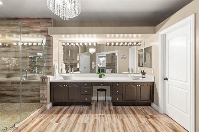 8100 Lake Hills Dr, Las Vegas, NV 89128 - bathroom with double vanity, wood finished floors, a shower stall, and a chandelier