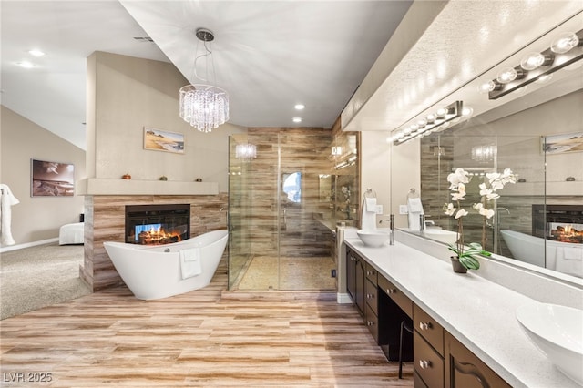 8100 Lake Hills Dr, Las Vegas, NV 89128 - full bathroom with a tile fireplace, double vanity, a freestanding bath, a shower stall, and recessed lighting