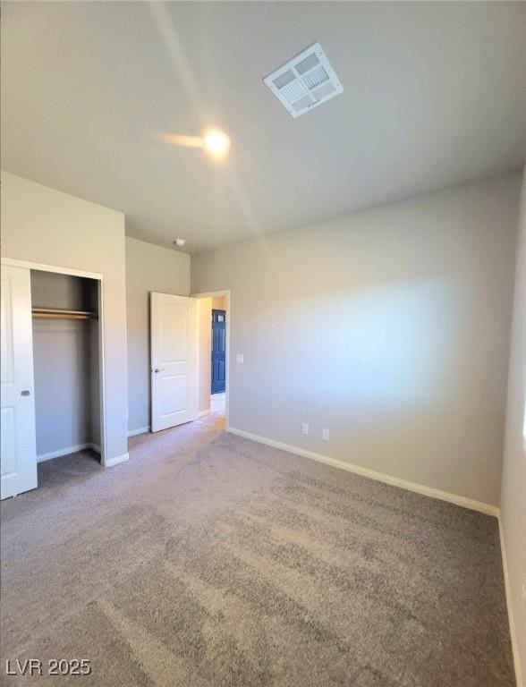 unfurnished bedroom with carpet flooring, baseboards, and a closet