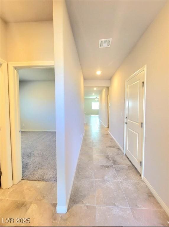 hall with baseboards and light tile patterned floors