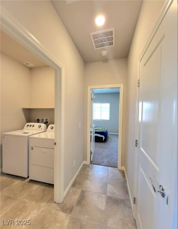 laundry area with washing machine and dryer and baseboards