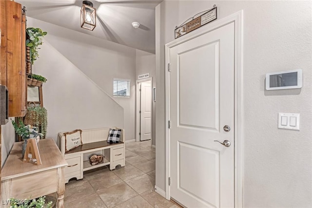 foyer entrance with light tile patterned flooring and baseboards