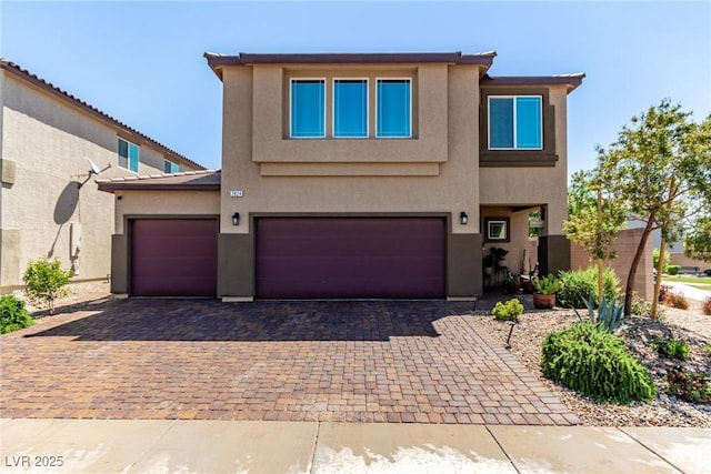 view of front of property with decorative driveway, stucco siding, and an attached garage