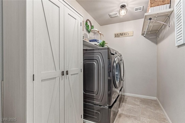 washroom featuring washing machine and dryer and baseboards