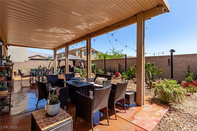 view of patio with a gazebo, outdoor dining space, a fire pit, and a fenced backyard