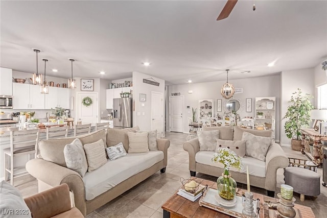 living room featuring recessed lighting, a chandelier, a ceiling fan, and light tile patterned floors