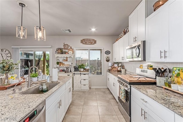 kitchen featuring stainless steel appliances, a sink, white cabinets, light tile patterned floors, and recessed lighting
