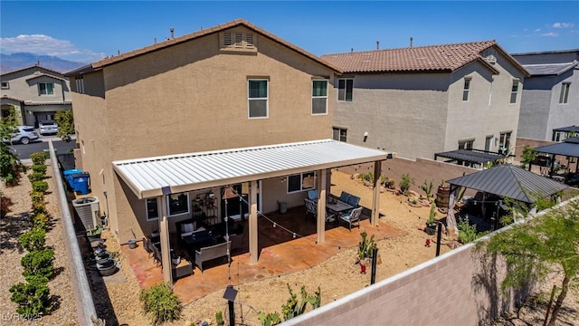 rear view of property featuring stucco siding, a patio area, cooling unit, and a tiled roof