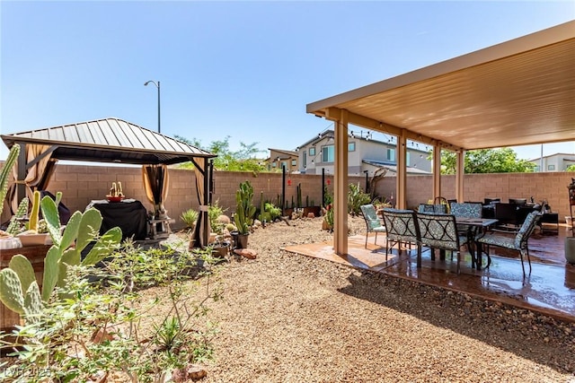 fenced backyard with a gazebo and a patio