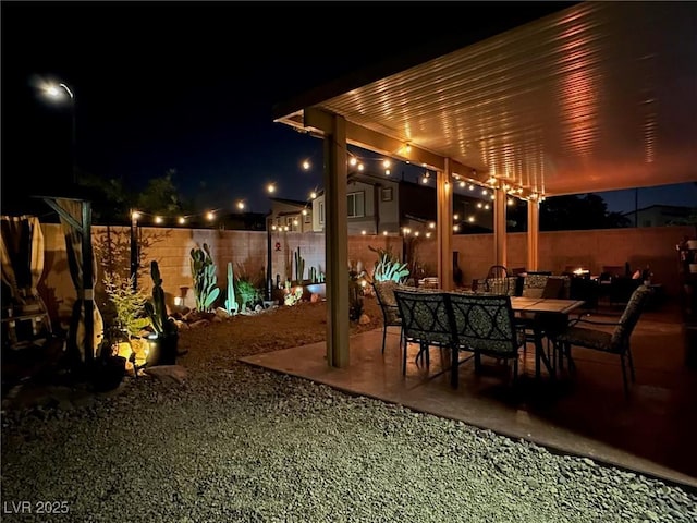 patio at night with a fenced backyard