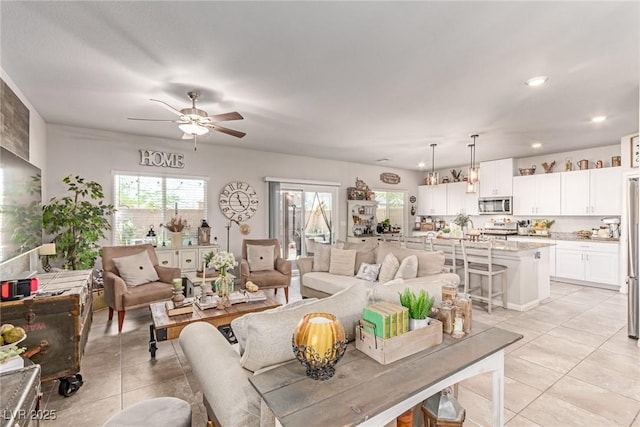 living room with light tile patterned flooring, a ceiling fan, and recessed lighting