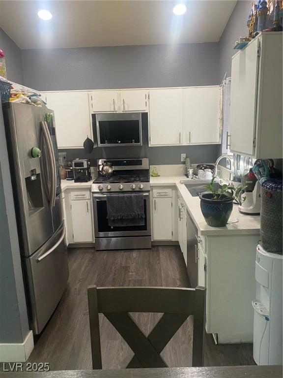 1841 Skywood Way, Las Vegas, NV 89142 - kitchen featuring stainless steel appliances, light countertops, dark wood finished floors, and white cabinets