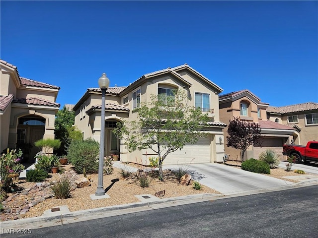 view of front of property with stucco siding, a tiled roof, driveway, and a garage