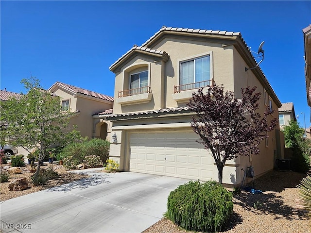 mediterranean / spanish home with a tiled roof, stucco siding, a garage, and driveway