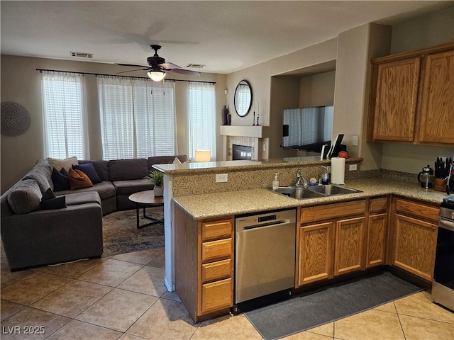 kitchen featuring stainless steel appliances, a sink, open floor plan, a peninsula, and ceiling fan