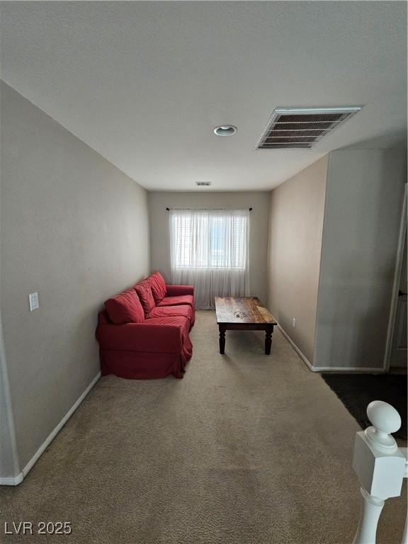living area featuring baseboards and carpet flooring