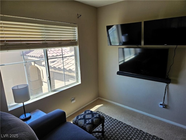 carpeted living area with baseboards
