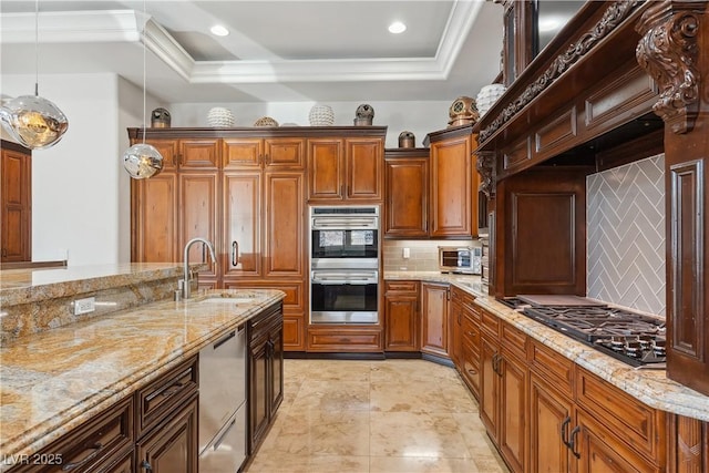 kitchen with appliances with stainless steel finishes, a sink, tasteful backsplash, a raised ceiling, and hanging light fixtures