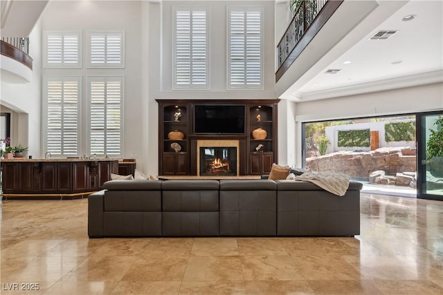 living area with a high ceiling and a premium fireplace