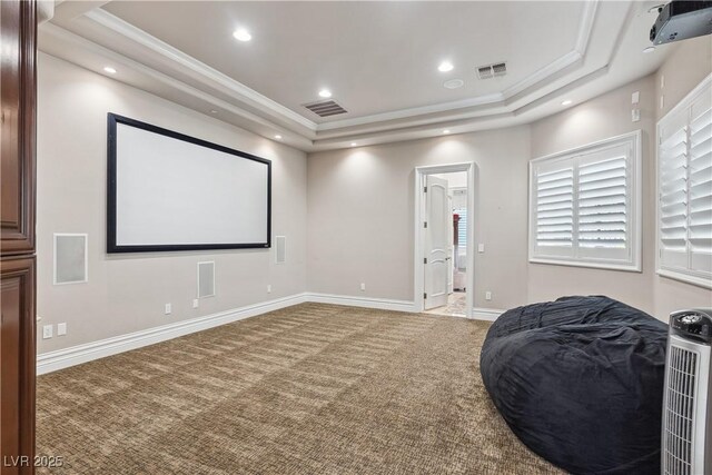 carpeted cinema room with a raised ceiling, ornamental molding, baseboards, and recessed lighting