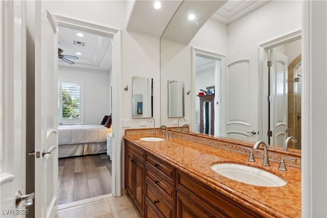 ensuite bathroom with double vanity, recessed lighting, and tile patterned flooring