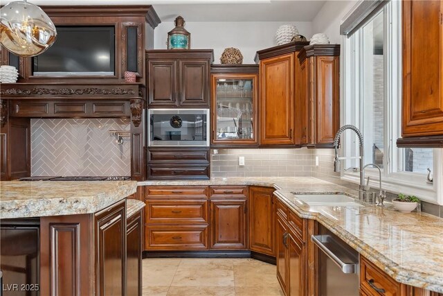 kitchen featuring a sink, built in microwave, dishwasher, light stone counters, and backsplash