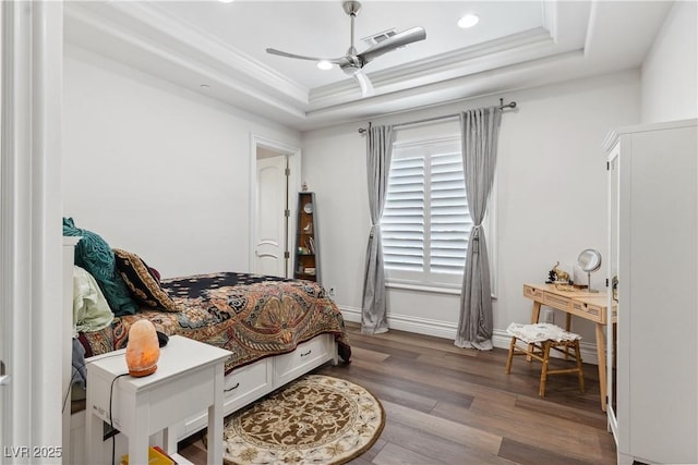 bedroom with a raised ceiling, wood finished floors, recessed lighting, ceiling fan, and ornamental molding
