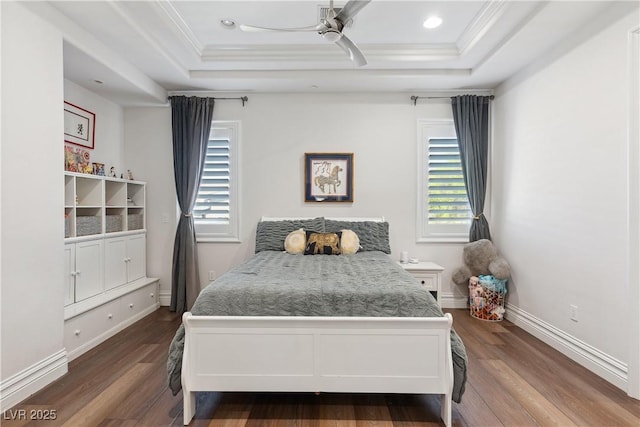 bedroom featuring a tray ceiling, dark wood-style flooring, baseboards, ornamental molding, and recessed lighting