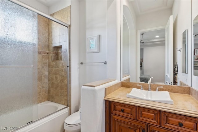 full bathroom featuring toilet, bath / shower combo with glass door, vanity, and a ceiling fan