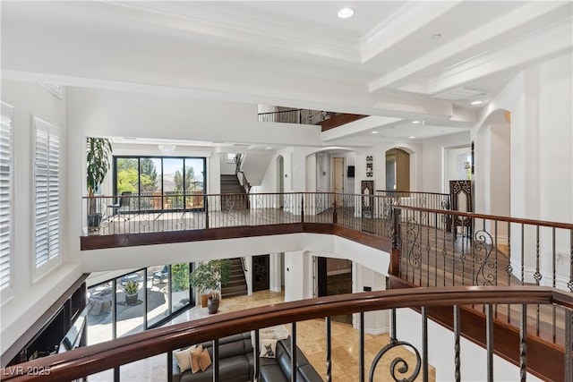 hallway featuring an upstairs landing, recessed lighting, and arched walkways