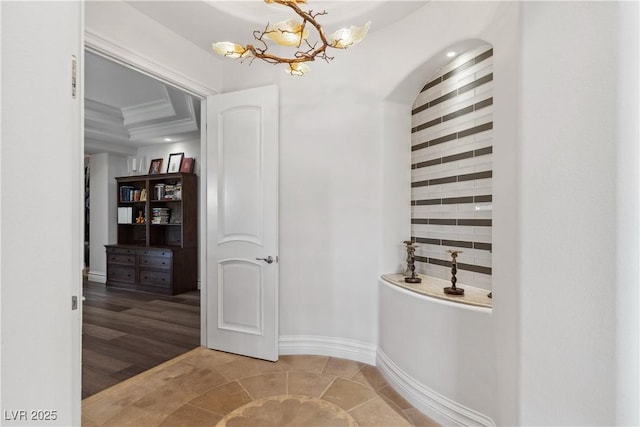 bathroom with a chandelier, baseboards, and ornamental molding