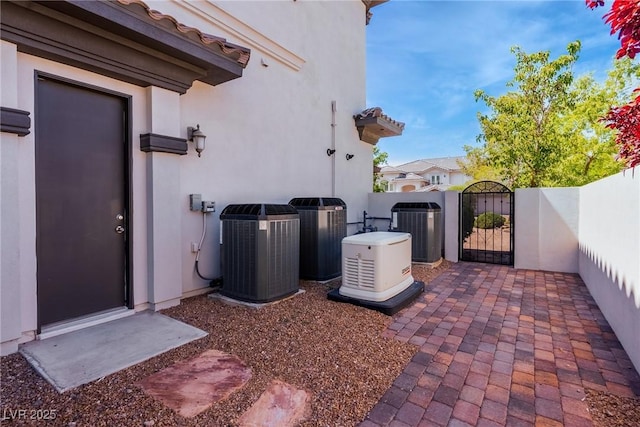 view of patio with a gate, central AC, and fence