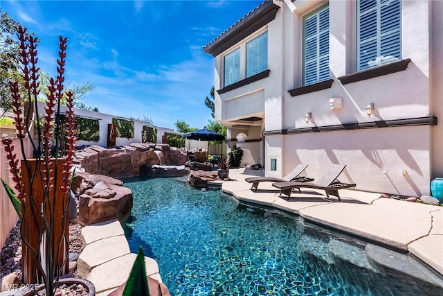 view of pool featuring a patio, a pool with connected hot tub, and fence